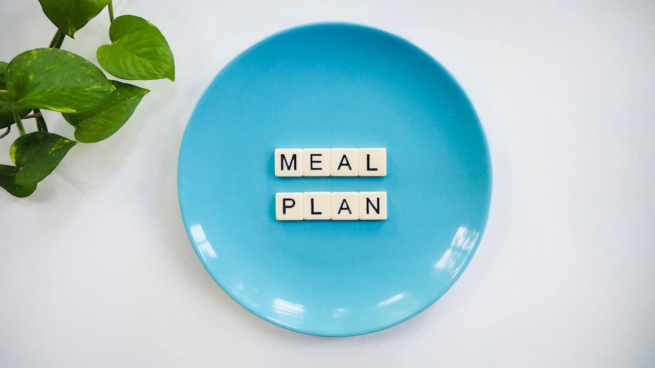 Crafting Captivating Headlines: Your awesome post title goes here Innovative meal planning concept using alphabet tiles on a blue plate with green leaves.